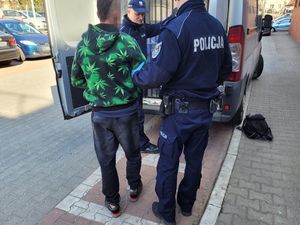 policjant wprowadza zatrzymanego do radiowozu