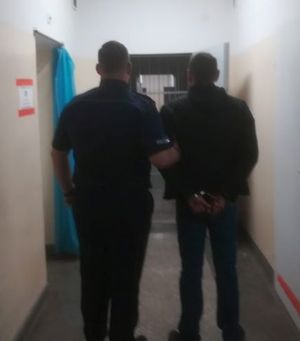 policjant prowadzi zatrzymanego mężczyznę