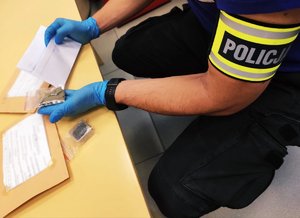 policjant z zabezpieczonymi narkotykami