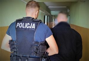 policjant prowadzi zatrzymanego