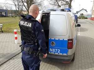 policjant wprowadził zatrzymanego do radiowozu