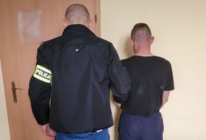 policjant stoi obok zatrzymanego