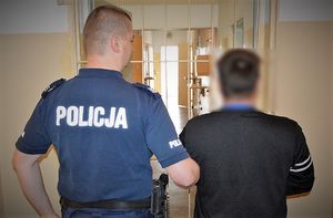 policjant prowadzi zatrzymanego