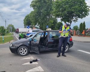 policjanci pracowali na miejscu wypadku z udziałem samochodu osobowego i motocykla