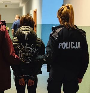 policjanci z zatrzymaną kobietą za kradzież plecaków i bmw