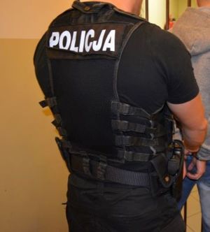 policjant trzyma zatrzymanego