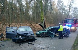 widok rozbitych pojazdów i pracujących na miejscu zdarzenia policjantów