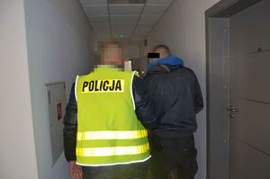 policjant prowadzi zatrzymanego mężczyznę