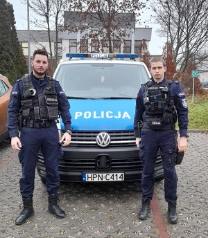 policjanci stojący przy radiowozie