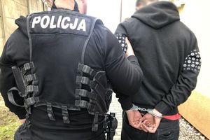 policjant prowadzi zatrzymanego mężczyznę