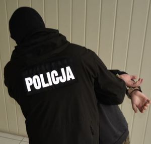 policjant prowadzi zatrzymanego