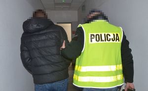 policjant prowadzi zatrzymanego