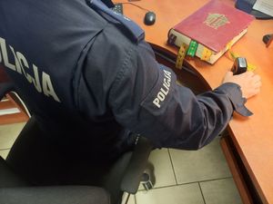 policjanci z zatrzymanym mężczyzną i skradzioną księgą z kościoła