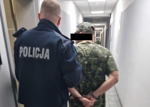 policjant z zatrzymanym mężczyzną