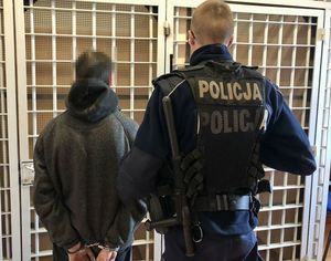 policjant stoi przed celą z zatrzymanym