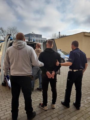 policjanci prowadzą zatrzymanego