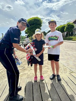 policjanci zakładają dzieciom na plaży opaski niezgubki