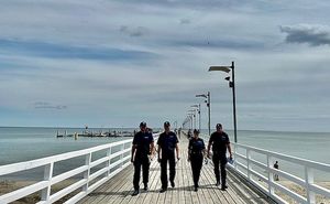 policjanci zakładają dzieciom na plaży opaski niezgubki