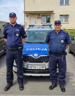 Policjanci stojący przy radiowozie