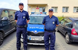 Policjanci stojący przy radiowozie