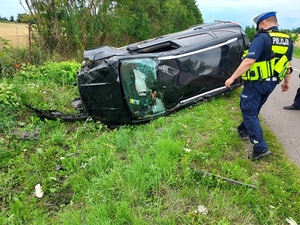 policjanci drogówki na miejscu dachowania pojazdu, którego kierowca był nietrzeźwy