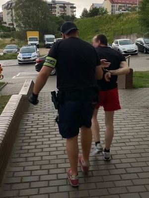 Policjanci prowadzący zatrzymanych