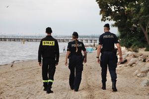 Podczas wspólnych działań policjanci wraz z strażakiem patrolują plażę i teren leśny