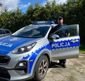 Policjant stojący przy radiowozie