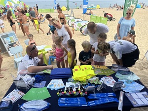 Policyjny namiot na plaży oraz odwiedzający plażowicze