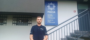 policjant, który uratował kobietę, stojący pod jednostką Policji