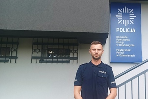 policjant, który uratował kobietę, stojący pod jednostką Policji