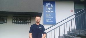 policjant, który uratował kobietę, stojący pod jednostką Policji