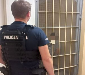 policjant przy pomieszczeniu dla zatrzymanych