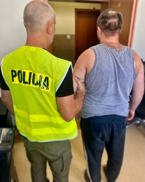 policjant z zatrzymanym mężczyzną i odzyskanymi przedmiotami