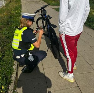 Policjanci rozmawiają z mieszkańcami o akcji rower. Na zdjęciu mieszkańcy i policjanci