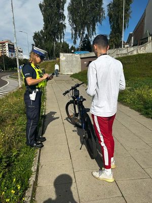 Policjanci rozmawiają z mieszkańcami o akcji rower. Na zdjęciu mieszkańcy i policjanci