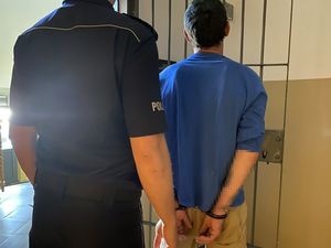 policjant stoi z zatrzymanym