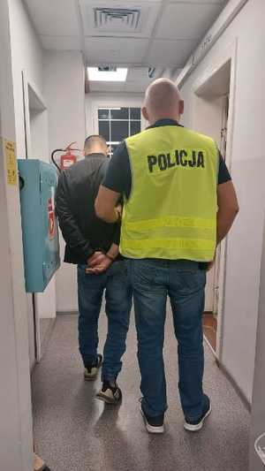 policjant prowadzi zatrzymanego mężczyznę