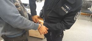 Policjant zakuwa w kajdanki osobę zatrzymaną