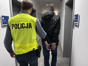 policjant prowadzi zatrzymanego