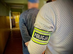 Policjant prowadzi zatrzymanego