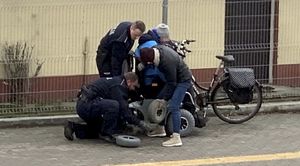 Policjanci pomagają mężczyźnie wymienić koło w wózku inwalidzkim