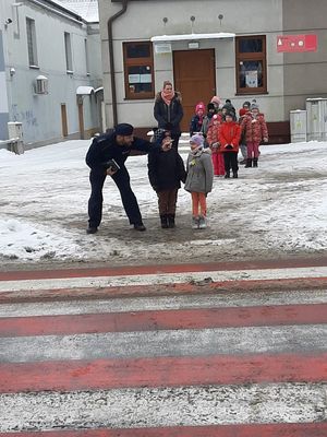 Policjant z dziećmi na przejściu dla pieszych