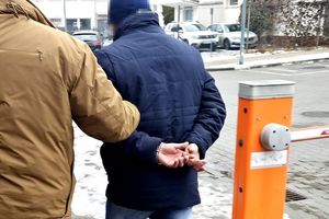 Policjant prowadzi zatrzymanego