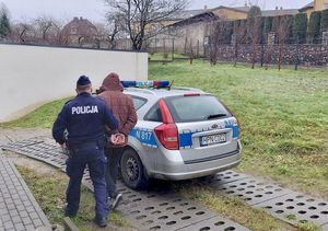 Policjant prowadzi zatrzymanego