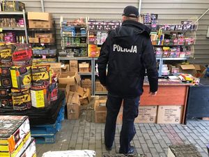 Policjant podcza kontroli punktu sprzedaży fajerwerek
