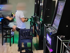 policjanci zatrzymują osoby w nielegalnym salonie gier hazardowych