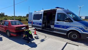 policjanci podczas kontroli stanu technicznego pojazdów