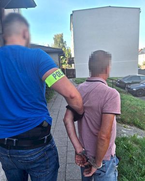 policjant z zatrzymanym poszukiwanym