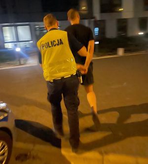 Policjant prowadzi zatrzymanego